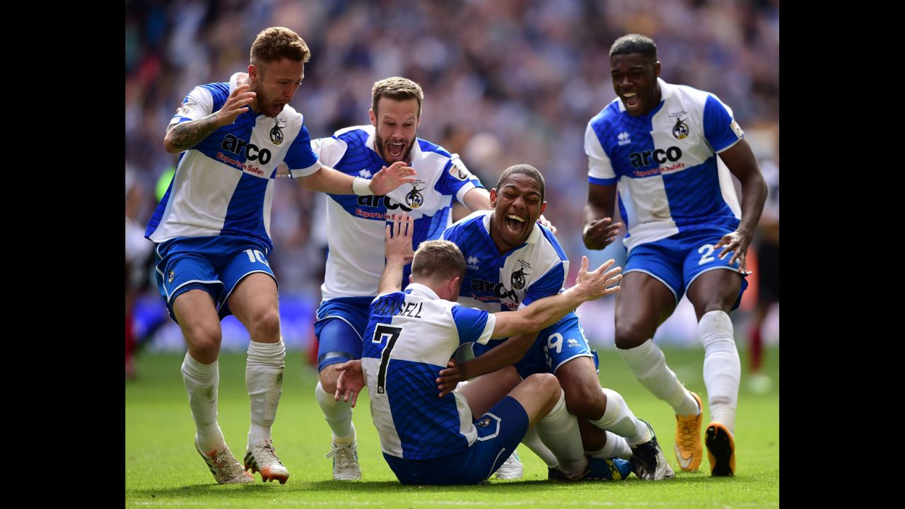 Players from Bristol Rovers run to teammate Lee Mansell after he scored the winning penalty in the shootout against Grimsby Town on Sunday, May 17. The playoff victory in London earned the Rovers a spot in League Two, which is the fourth tier of English soccer.  