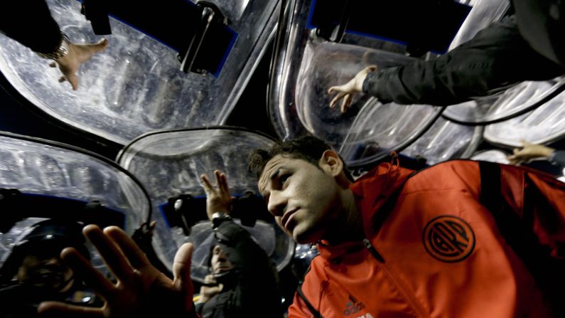 River Plate striker Rodrigo Mora leaves the field under the protection of police shields after a match against rivals Boca Juniors was abandoned Friday, May 15, in Buenos Aires. The match was stopped because four River Plate players <a href="index.php?page=&url=http%3A%2F%2Fwww.cnn.com%2F2015%2F05%2F15%2Ffootball%2Fboca-juniors-river-plate-spray%2F" target="_blank">were hit with pepper spray</a> as they came out for the second half. In the ensuing chaos, as many as 1,200 police officers were deployed to keep control of the opposing fans.