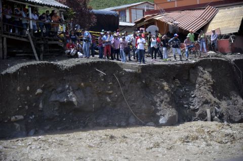 People stand near the site of a massive landslide in Salgar, Colombia, on Monday, May 18. The landslide tore through a ravine before dawn, killing more than 80 people, officials said.