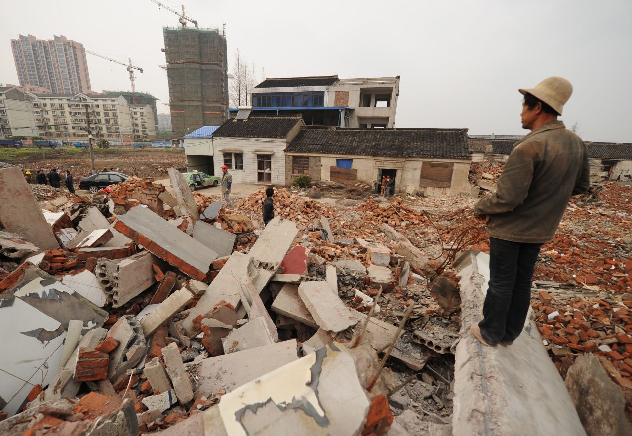 This picture taken on March 13, 2013 shows a worker looking out over a rubble-filled construction site where 75-year-old Yao Baohua's house still stands in Changzhou, a city in eastern China's Jiangsu province. 