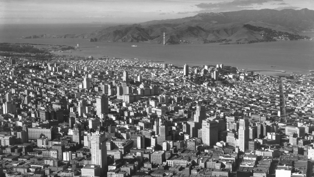 This aerial image from 1934 shows downtown San Francisco and construction of the Golden Gate Bridge in the background. The bridge's north Marin Tower is nearly completed, although the southern one had yet to be erected. 