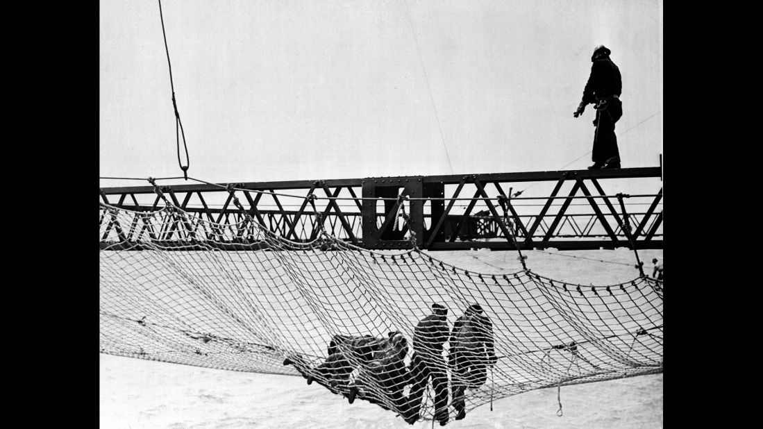 Workers in 1935 install the first section of a huge safety net, at a cost of $98,000, that extended beneath the bridge from shore to shore. The netting was added to catch workers who tumbled off their precarious steel perches above.