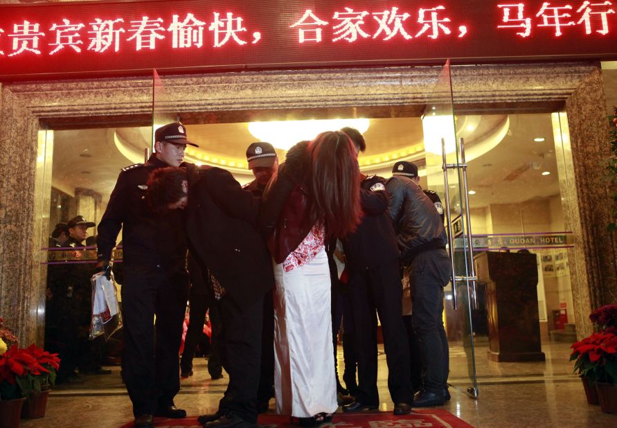 This picture taken late on February 9, 2014 shows Chinese police taking away alleged sex workers and clients at an entertainment center in Dongguan, sometimes called China's "Sin City." 