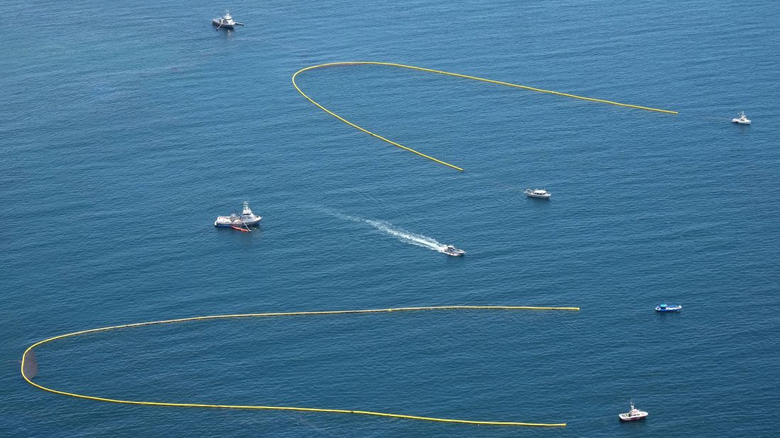 Ships pulling booms attempt to collect oil from the spill on May 20.