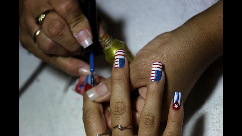 A woman has her nails painted in the likeness of the Cuban and U.S. flags inside her Havana home in December.