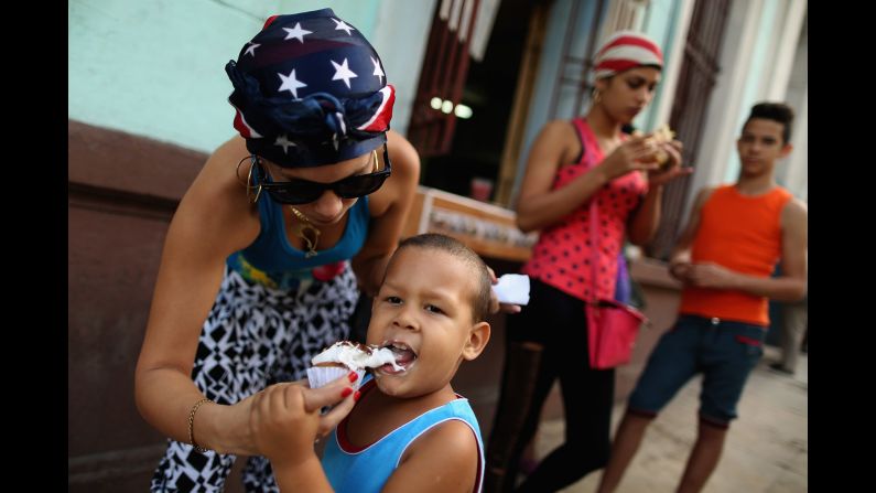 A woman wearing an American flag bandana gives her son some ice cream in Havana in January.