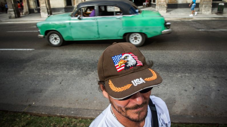 A car passes a man in Havana wearing a cap displaying the U.S. flag in February.
