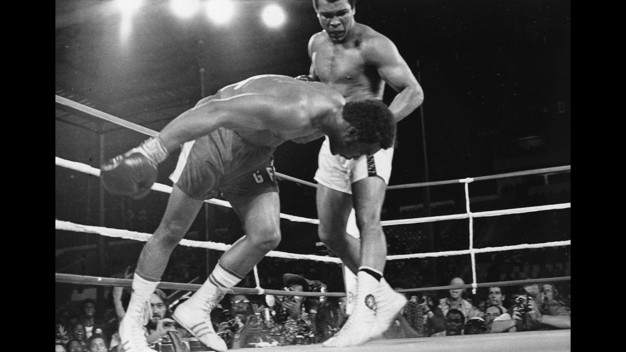 Muhammad Ali watches heavyweight champion George Foreman fall to the canvas during their title bout in Kinshasa, Zaire, in October 1974. Ali's upset victory over the undefeated Foreman won him back the titles he was stripped of in 1967 for refusing induction into the U.S. Army.