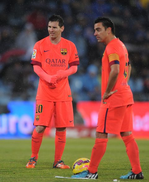 Lionel Messi and Xavi Hernandez weigh up their options during a match at Getafe in 2014.