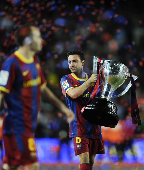 Xavi holds aloft the Spanish league trophy -- he won it eight times with Barcelona.