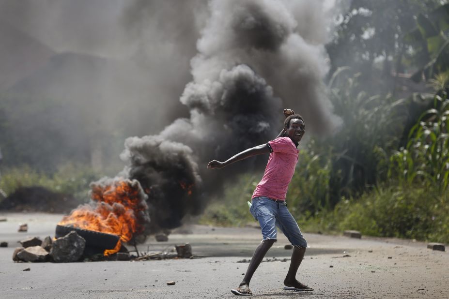 An anti-government protester throws a rock at police officers in Bujumbura on Thursday, May 21.