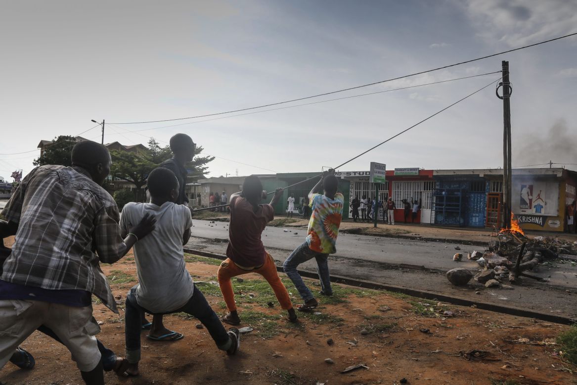 Protesters pull electrical cable to topple a power pole at an anti-government demonstration in Bujumbura on May 21.