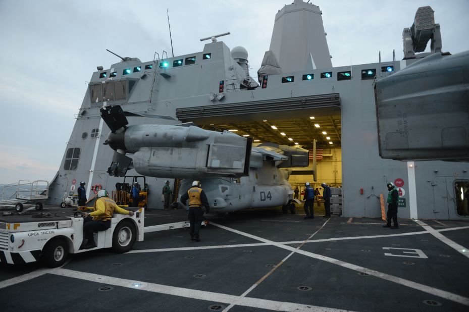 Sailors aboard the amphibious transport dock ship USS Mesa Verde (LPD 19) stow an MV-22 Osprey in the hangar bay.