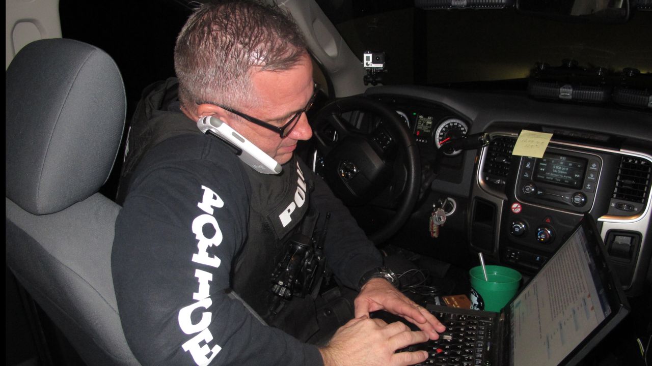 North Miami Beach, Florida, police Detective Craig Catlin checks a fraud suspect's information in a police database.