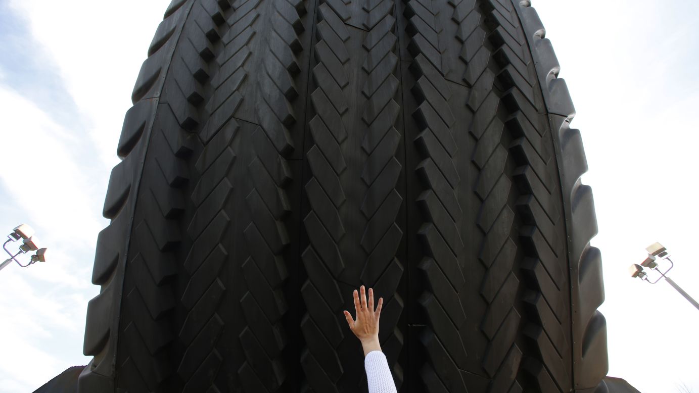 A visitor touches the Uniroyal Giant Tire in Allen Park, Michigan, on Wednesday, May 20. The 80-foot tire has stood alongside Interstate 94 since 1965, a year after it debuted at the New York World's Fair.