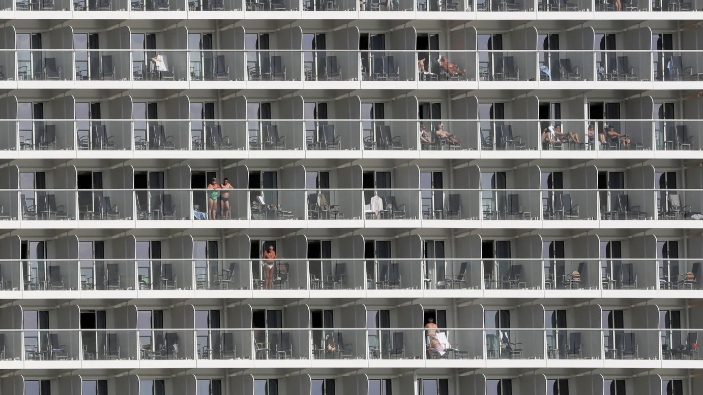Vacationers are seen on cabin balconies of the Quantum of the Seas cruise ship while it was docked in Piraeus, Greece, on Monday, May 18.