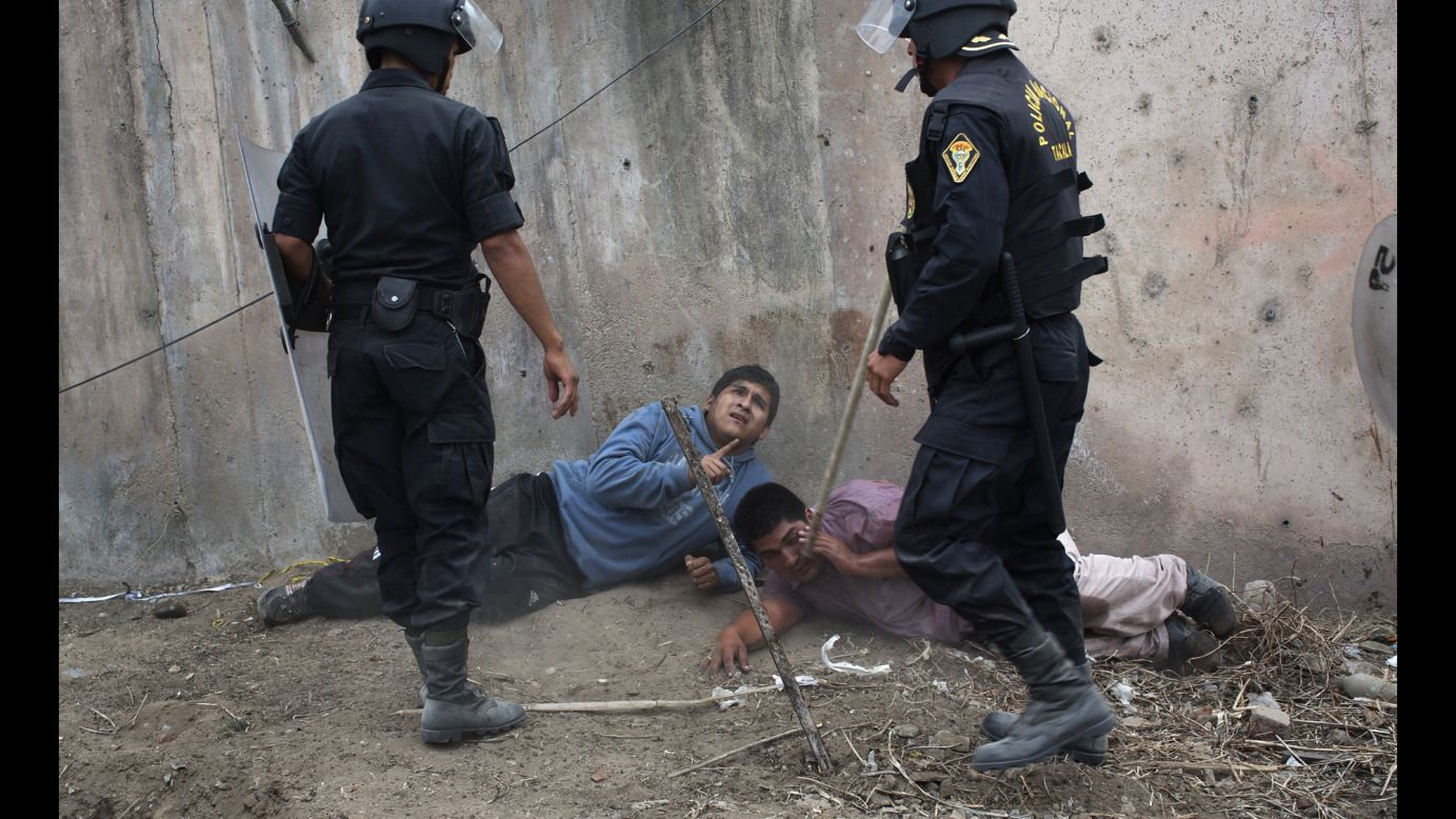 Riot police detain men during a land eviction in Lima, Peru, on Tuesday, May 19. Hundreds of people squatted on land that, according to the Ministry of Culture, is an archaeological site.