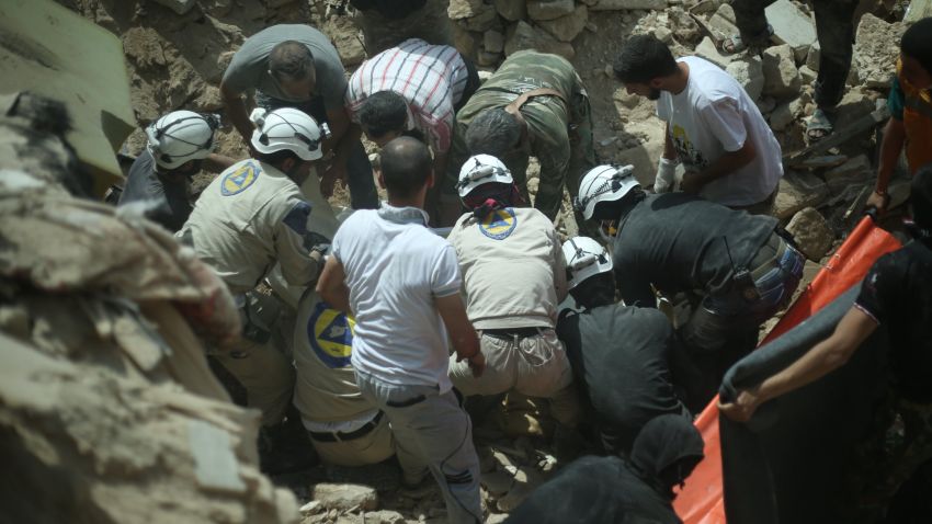 ALEPPO, SYRIA - MAY 20: Syrian emergency services personnel accompanied with Syrian local people remove the body of a Syrian from the rubble of buildings following a reported barrel bomb attack by government forces on the Qadi Askar district of the northern Syrian city of Aleppo on May 20, 2015. (Photo by Salih Mahmud Leyla/Anadolu Agency/Getty Images)