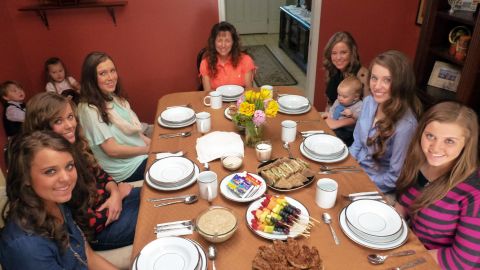Michelle Duggar sits at the dinner table with other women and girls in the family.
