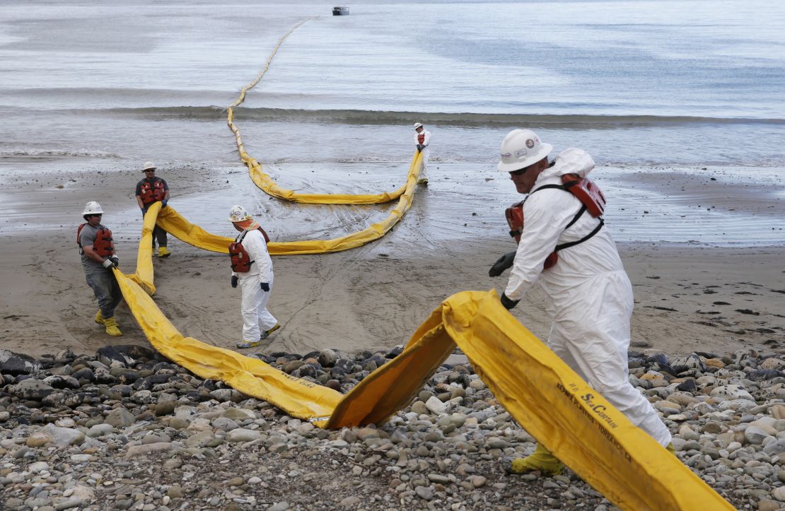 Workers prepare an oil containment boom at Refugio State Beach, north of Goleta, California, on May 21.