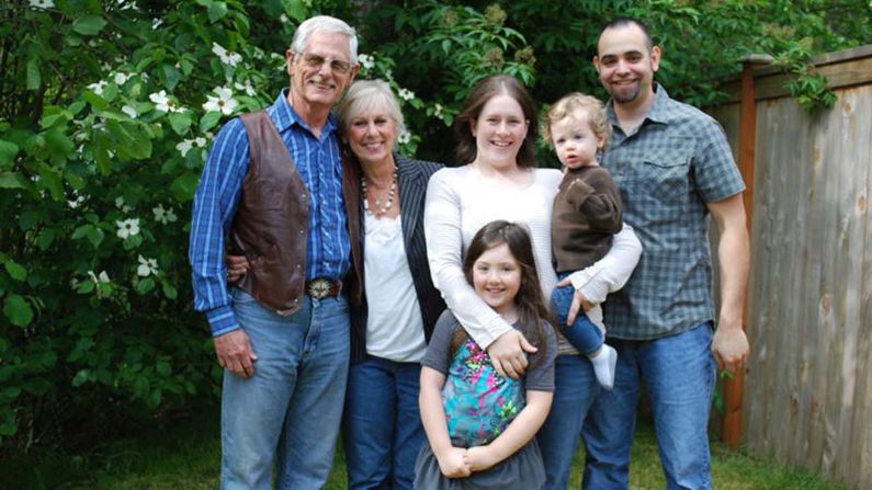 Travis Tolliver poses with his adoptive U.S. parents, his wife and their two children in 2010. His parents were told Travis was an abandoned baby.