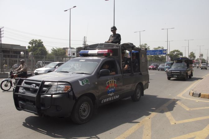 Police officials and paramilitary troops can be seen patrolling outside Gaddafi Stadium, where the attack on the Sri Lankan team took place in 2009.  