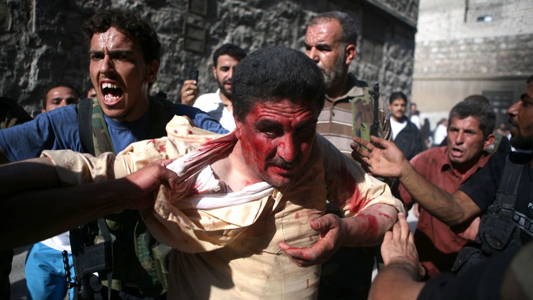 Rebel fighters with the Free Syrian Army capture a police officer in Aleppo, Syria, who they believed to be pro-regime militiaman on July 31, 2012. Dozens of officers were reportedly killed as rebels seized police stations in the city.