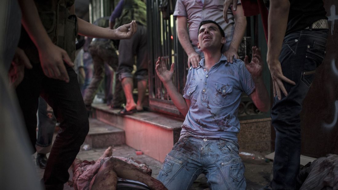 Family members mourn the deaths of their relatives in front of a field hospital in Aleppo on August 21, 2012.