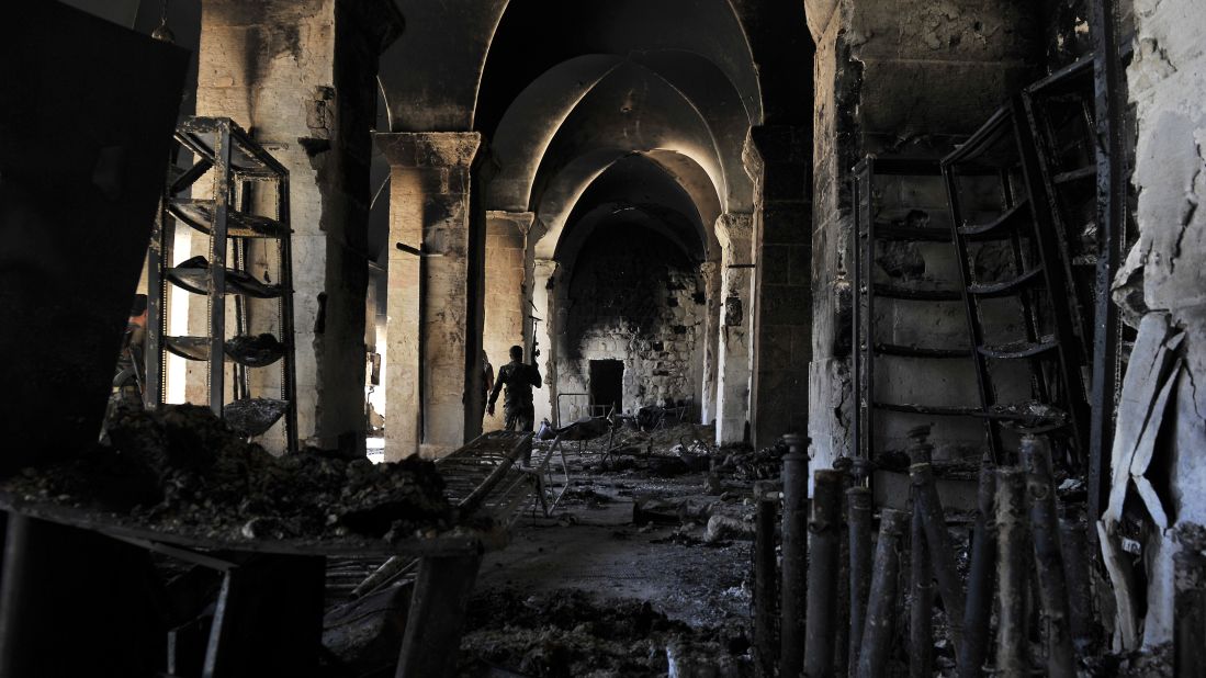 A Syrian rebel walks inside a burnt section of the Umayyad Mosque in Aleppo hours before the Syrian army retook control of the complex on October 14, 2012.