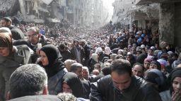 Residents wait to receive food aid distributed by the U.N. Relief and Works Agency at the besieged al-Yarmouk camp, south of Damascus, on January 31, 2014.