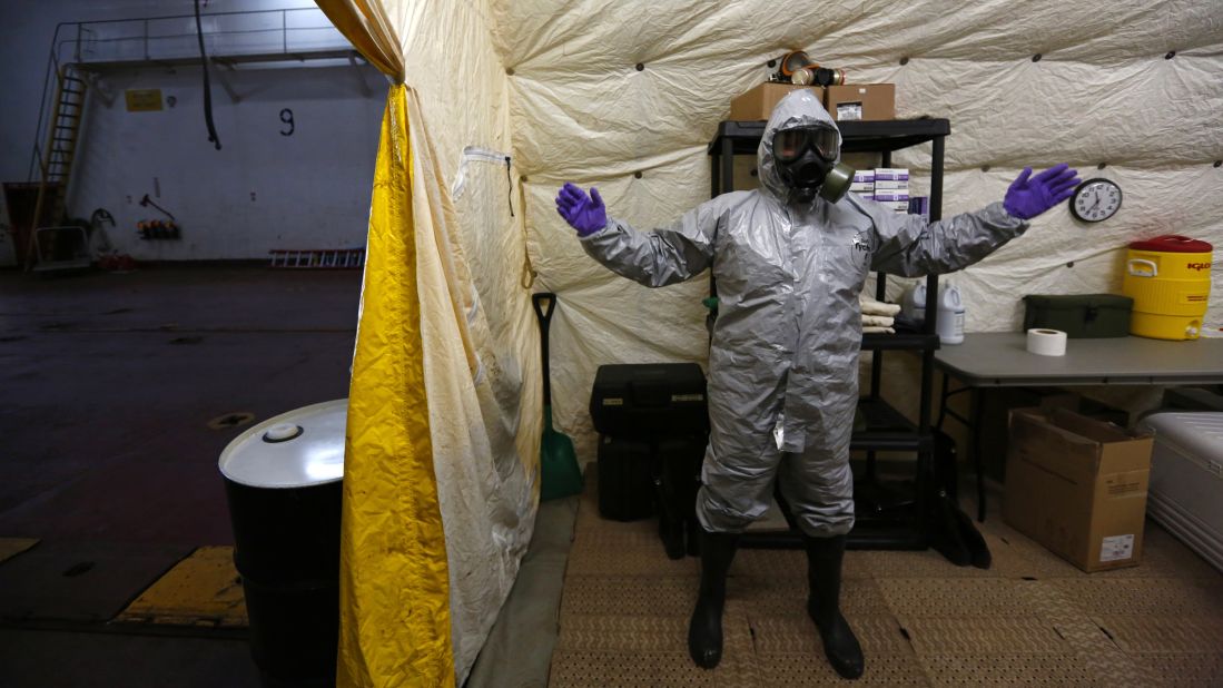 A US ship staff member wears personal protective equipment at a naval airbase in Rota, Spain, on April 10, 2014. A former container vessel was fitted out with at least $10 million of gear to let it take on about 560 metric tons of Syria's most dangerous chemical agents and sail them out to sea, officials said.