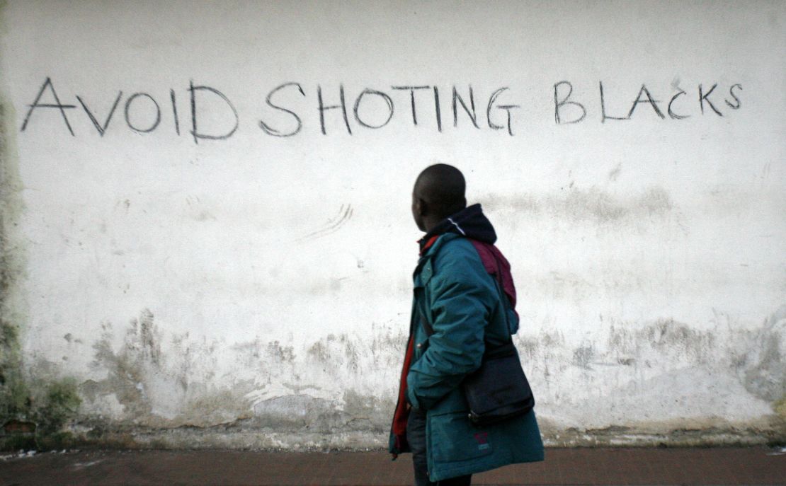 An immigrant worker reads graffiti on a wall in the Italian town of Rosarno in 2010.