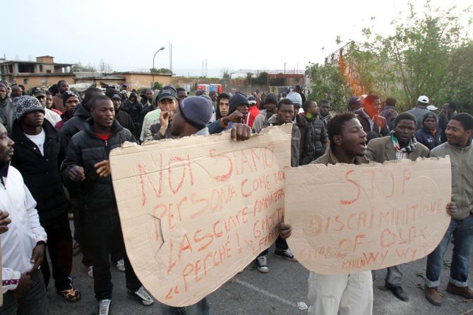 Rosarno has seen conflict between African migrants and the native population in recent years. Here, immigrant workers hold placards as they protest in the Calabrian town in 2010.