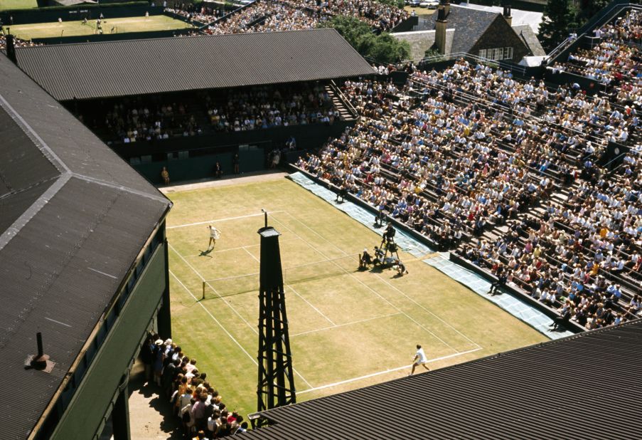 A general view of a match in progress on the Number One Court at Wimbledon in 1970. Centre Court's roofline can be seen to the left.