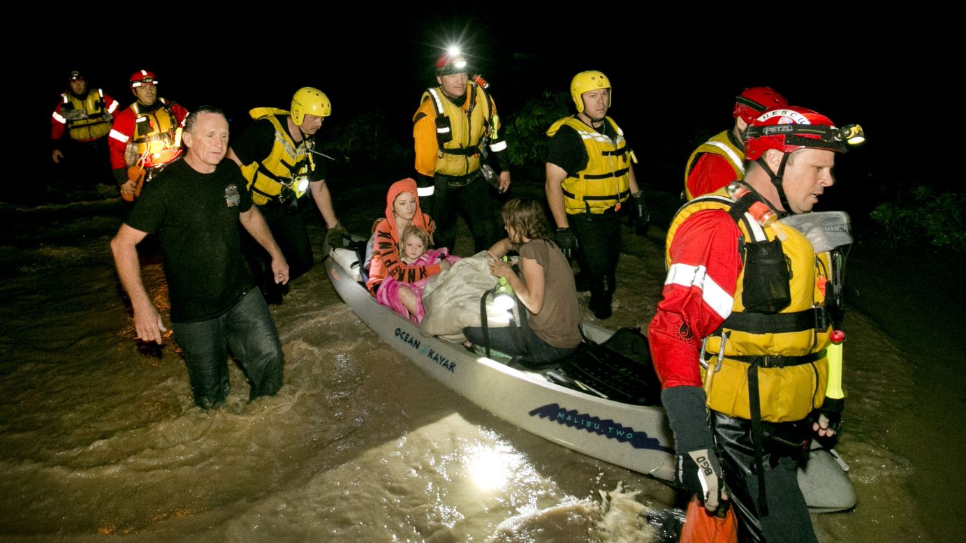 Retha Norris, Ally Smith and Christina Norris, all seated in the canoe, are rescued by firefighters on May 24 after they clung to a tree in Kyle, Texas.