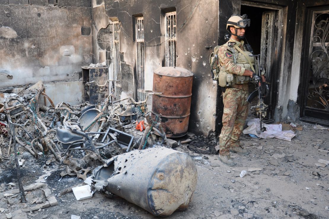 An Iraqi security forces member stands outside a burned house during fighting with anti-government forces Thursday in Ramadi, west of Baghdad.