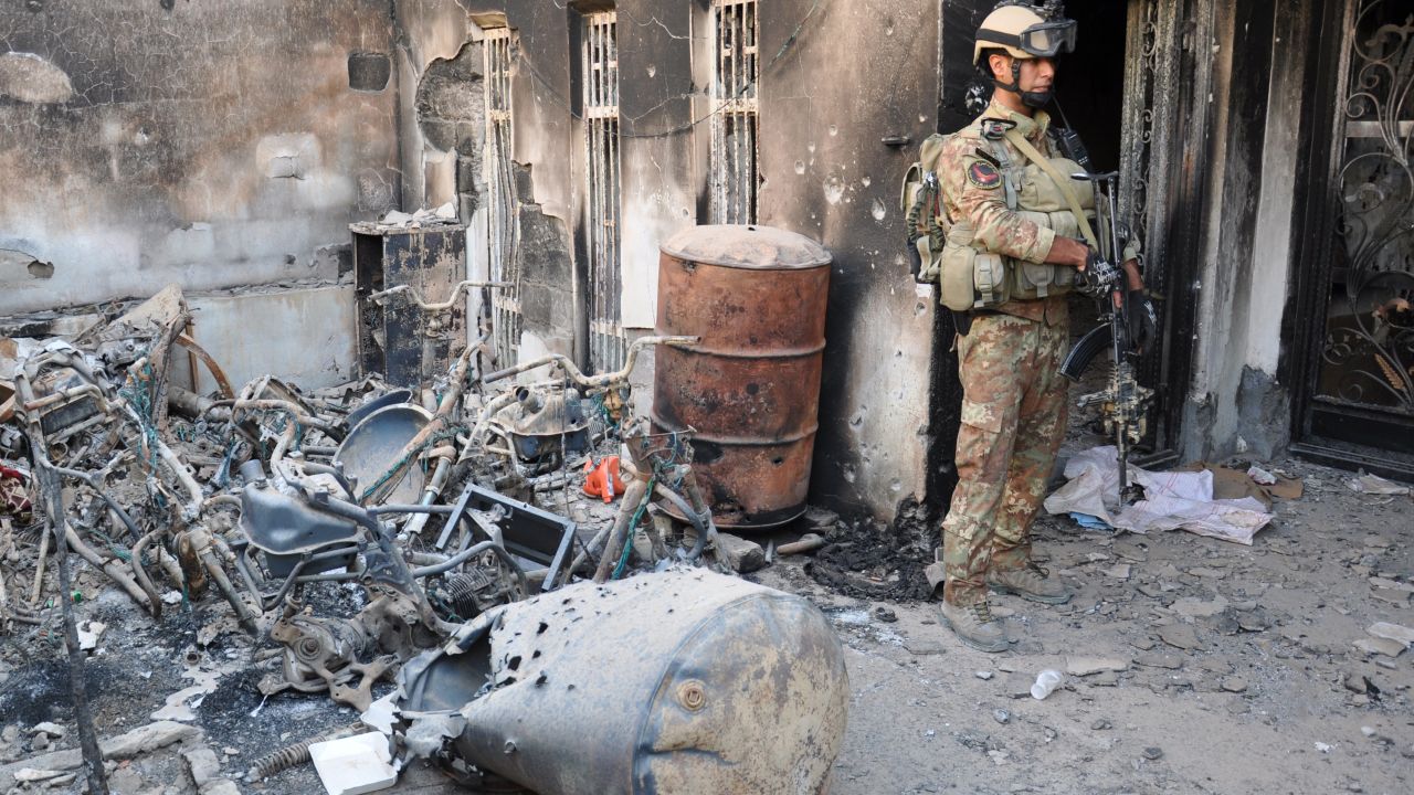 An Iraqi security forces member stands outside a burned house during fighting with anti-government forces Thursday in Ramadi, west of Baghdad.