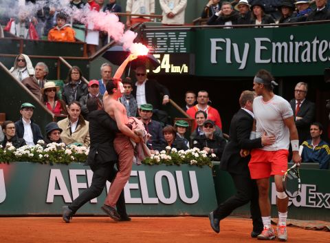 Rafael Nadal looks on as security guards restrain the protester. The Spaniard went on to beat David Ferrer in that 2013 final. 