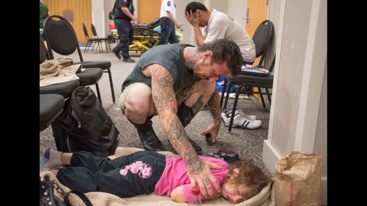 David Barry consoles his 5-year-old daughter, Marley, while she tries to sleep in a flood evacuee room created at the San Marcos Activity Center on May 24.
