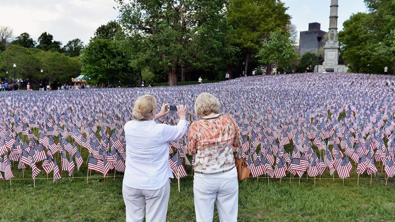 Visitors in Boston take a picture May 22 of American flags placed by the Massachusetts Military Heroes Fund. The flags represent fallen military members from Massachusetts.
