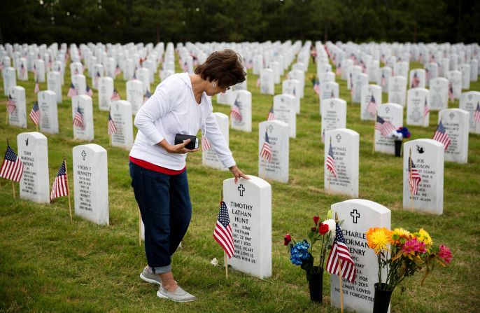 Vickie Hunt touches the tombstone of her late husband, Vietnam veteran Timothy Hunt, while visiting Georgia National Cemetery in Canton, Georgia, on Monday, May 25. "I come every Memorial Day," Hunt said. "As soon as I go through the gates here it brings me a sense of peace."