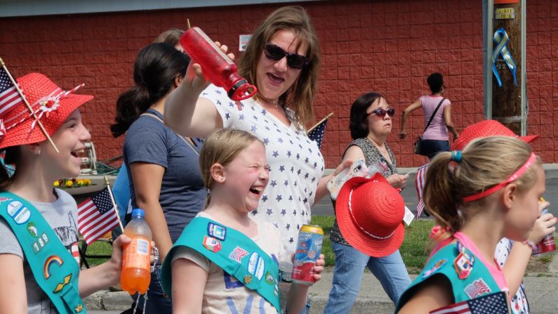 A young Girl Scout laughs while getting cooled off during a parade in Washingtonville, New York, on May 25.