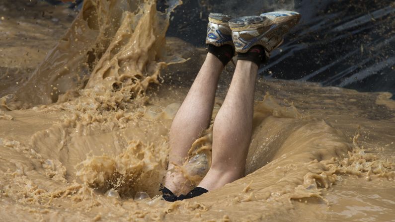 A participant dives into a mud pool while taking part in a Mud Day obstacle race in Toledo, Spain, on Saturday, May 23.