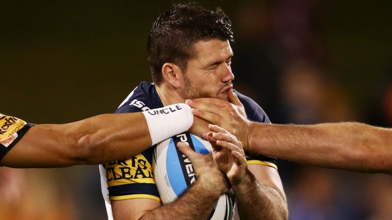 Lachlan Coote of the North Queensland Cowboys is hit in the face by tacklers during a National Rugby League match in Sydney on Saturday, May 23. 