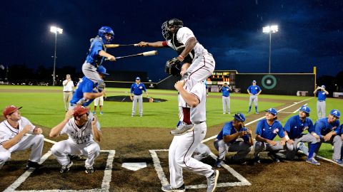 Baseball players from Troy and Texas-Arlington joust playfully during a weather delay in the Sun Belt tournament on Wednesday, May 20.