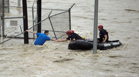 Rescue personnel grab the the hand of a man who was stranded in rushing water in Austin on May 25.