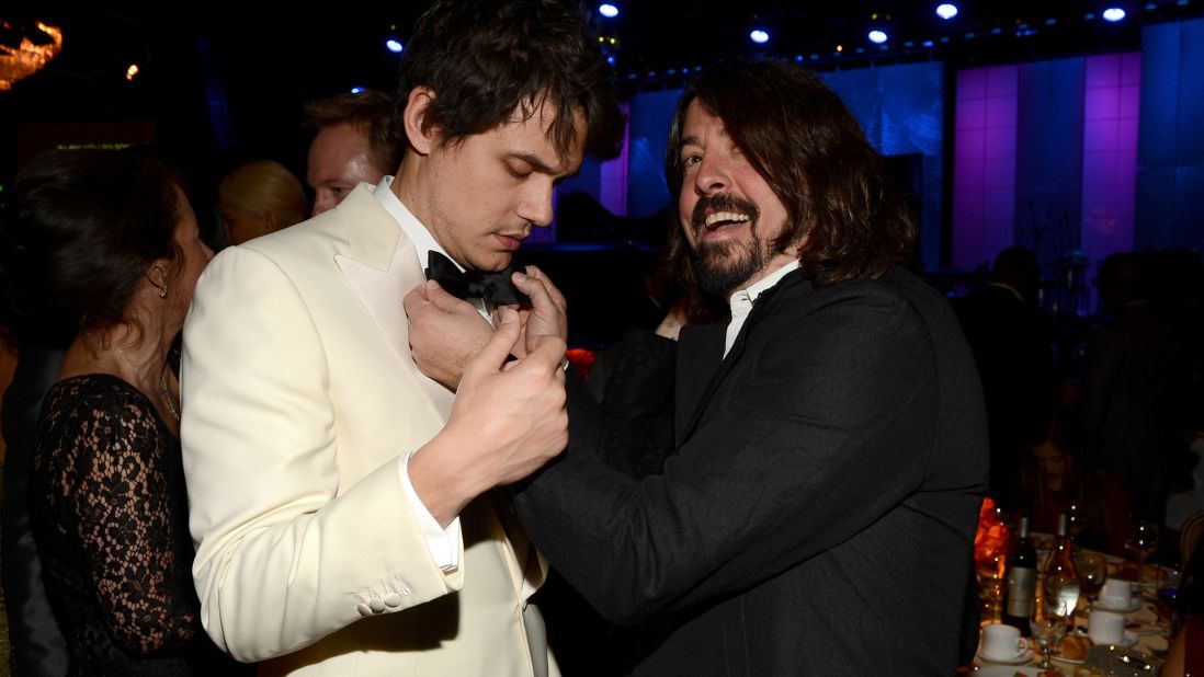 Grohl adjusts John Mayer's bow tie at the 2013 Grammy Awards.