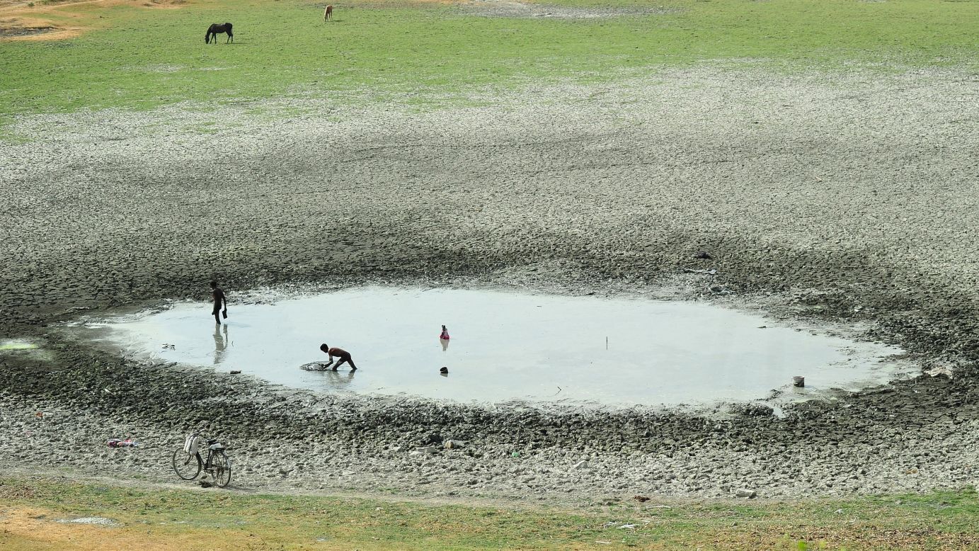 Fishermen attempt to catch fish in a shrunken pond in Phaphamau, India, on Tuesday, May 26.