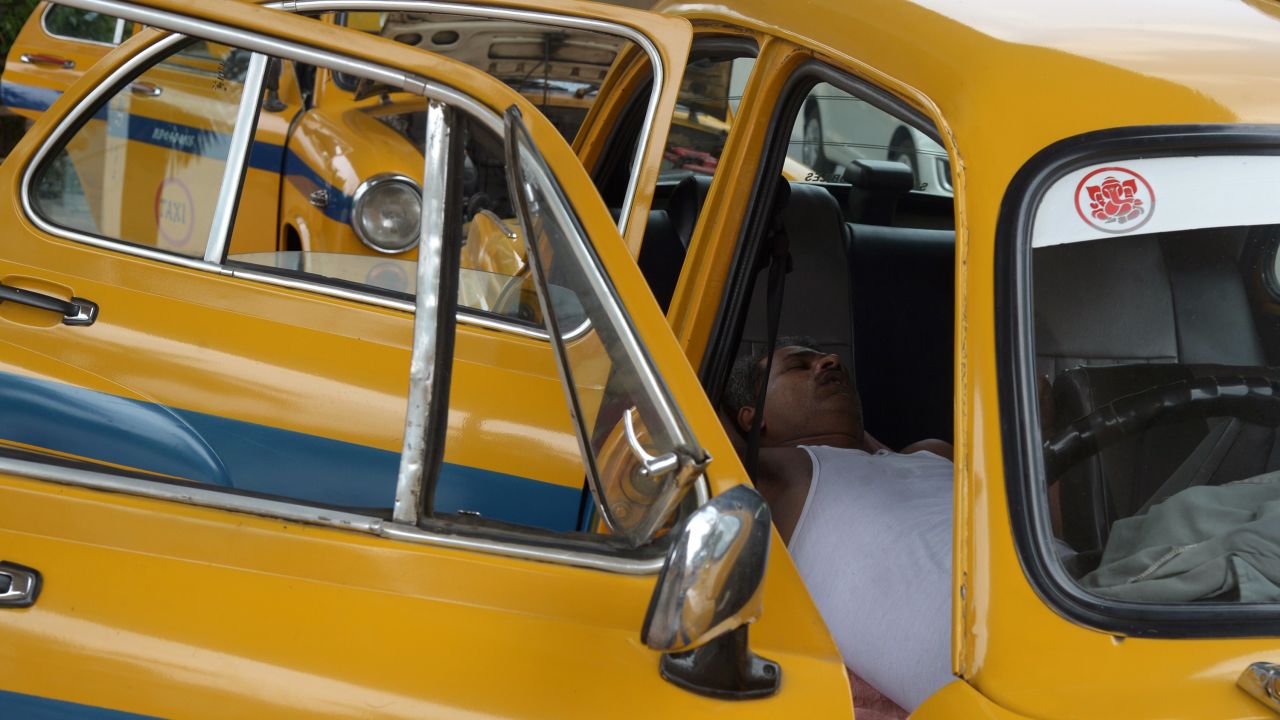 A taxi driver rests in his parked car in Kolkata, India, on Monday, May 25.