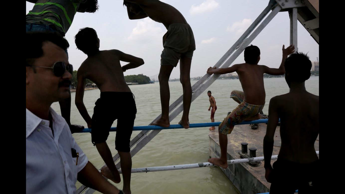 People in Kolkata flock to the murky waters of the Hooghly River for a cooling dip on Friday, May 15.